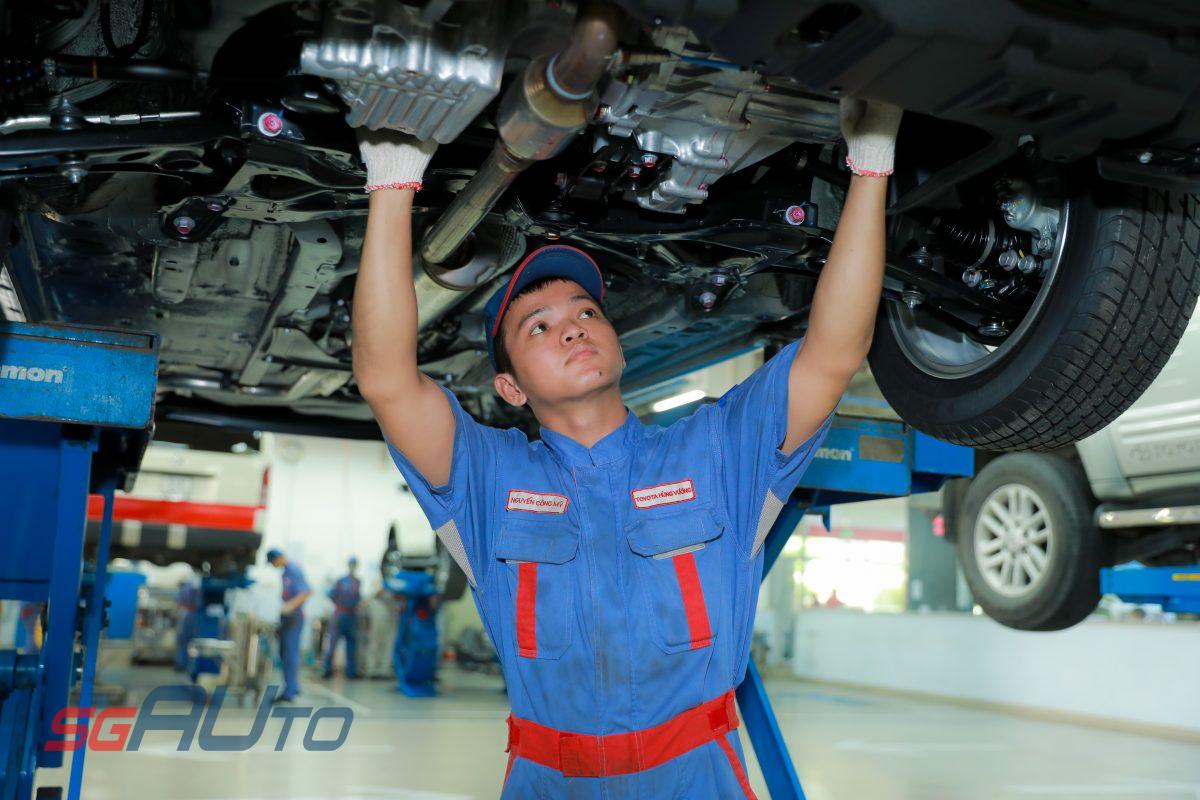 kỹ thuật viên đang kiểm tra gầm ô tô